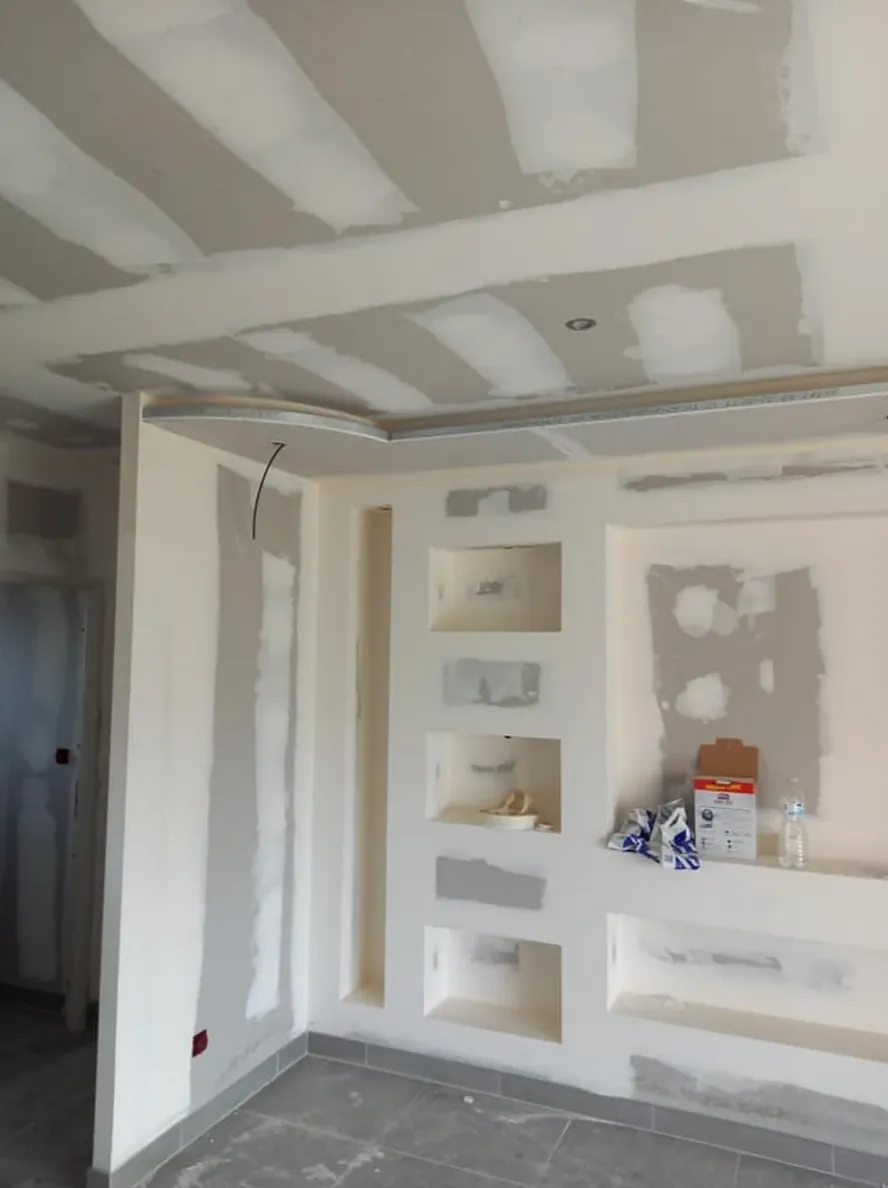 Mur de niches en plaques de plâtre aux joints enduits, plafond en plaques jointées, carrelage posé au sol