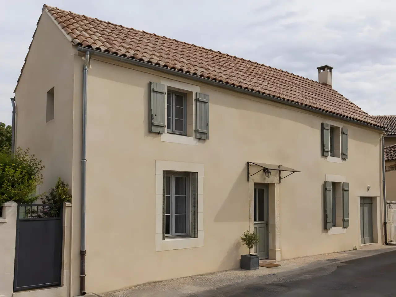 Maison de village enduite aux volets gris au toit de tuiles bien droit, ligne de faîtage rectiligne
