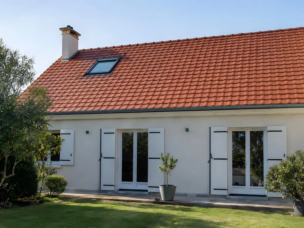 La même maison au toit de tuiles rouges complet et régulier, pelouse débarrassée des débris