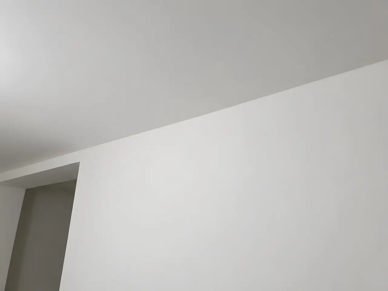 Le même angle enduit et poncé : mur et plafond lisses, plus aucun joint ne se devine