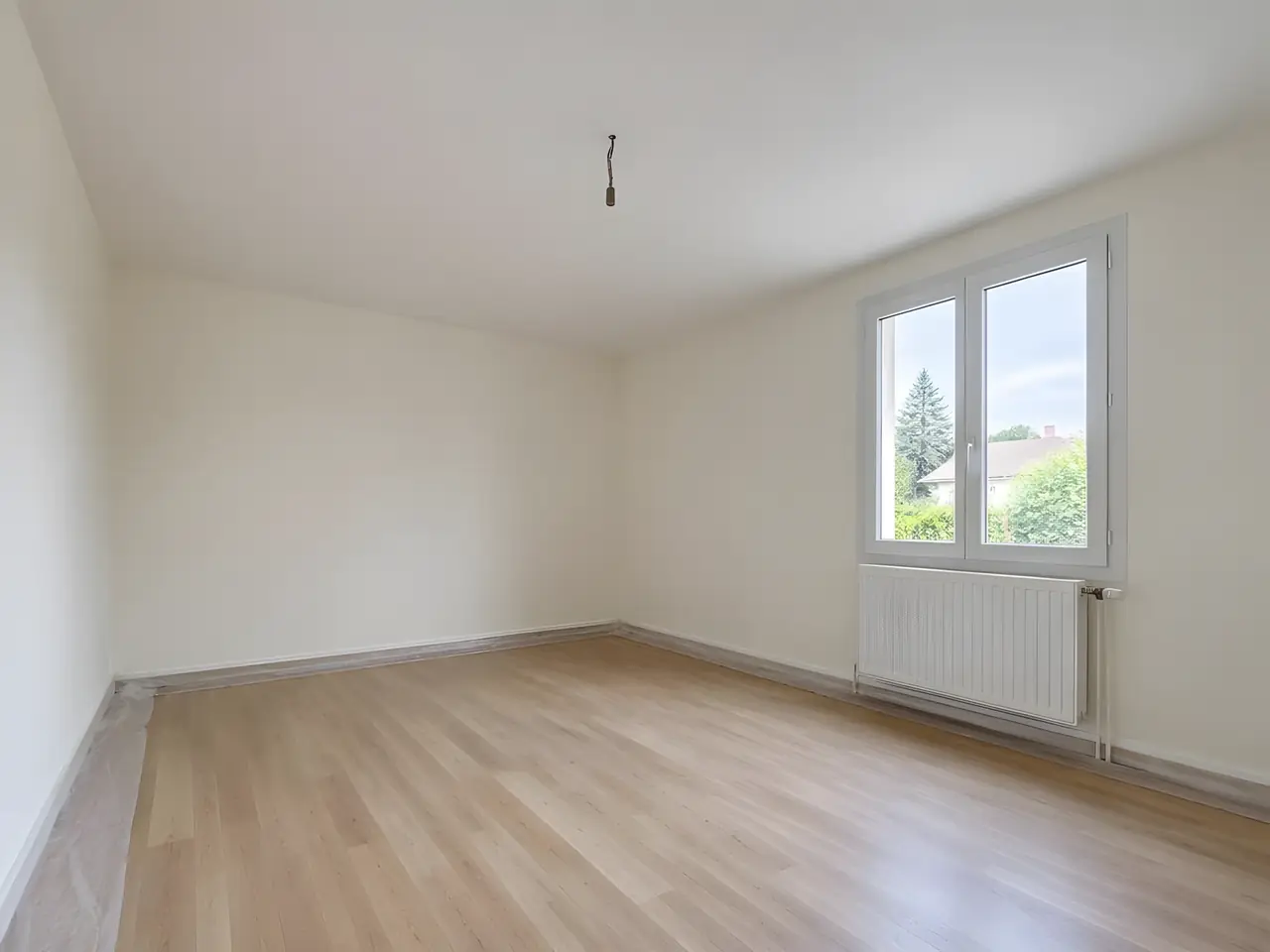 La même chambre au plafond neuf, blanc et plat d’un mur à l’autre, fenêtre et radiateur à droite